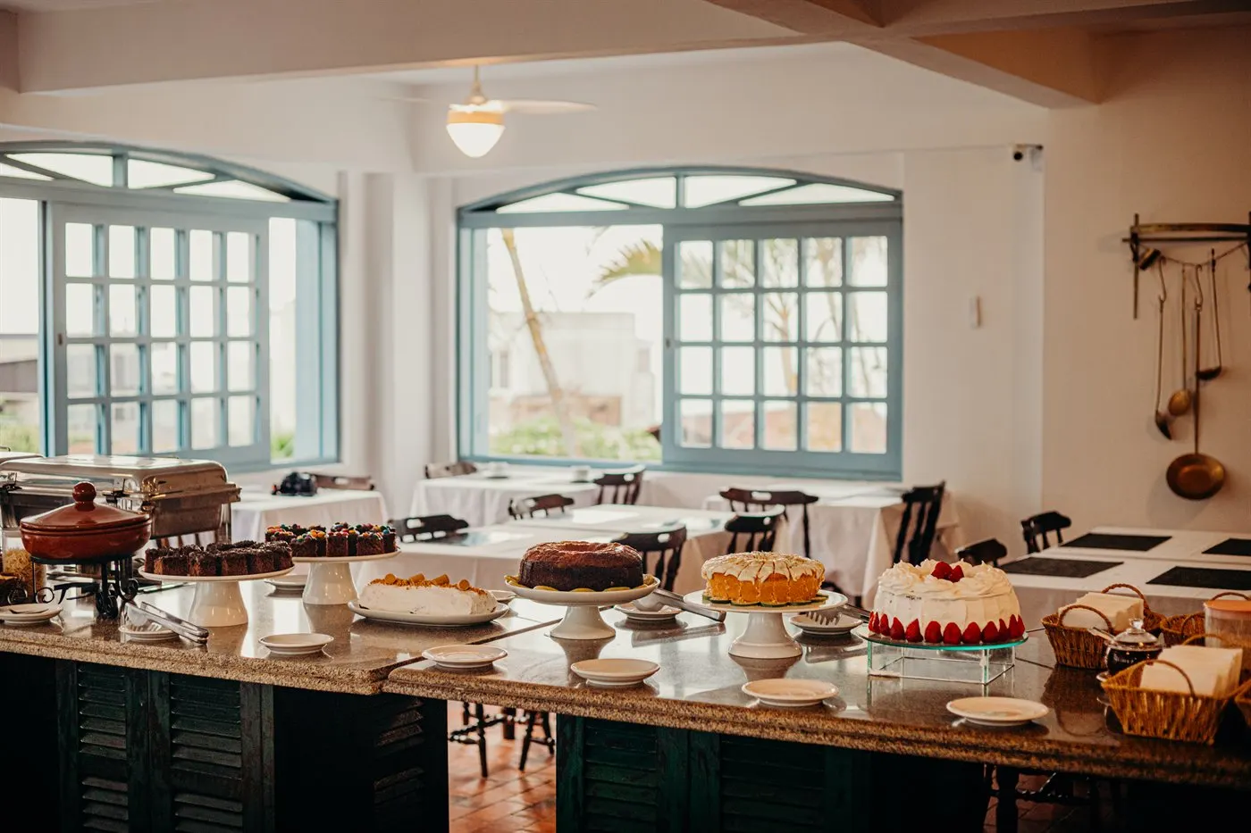 O buffet do café da manhã da pousada, com sucos, frutas e frios