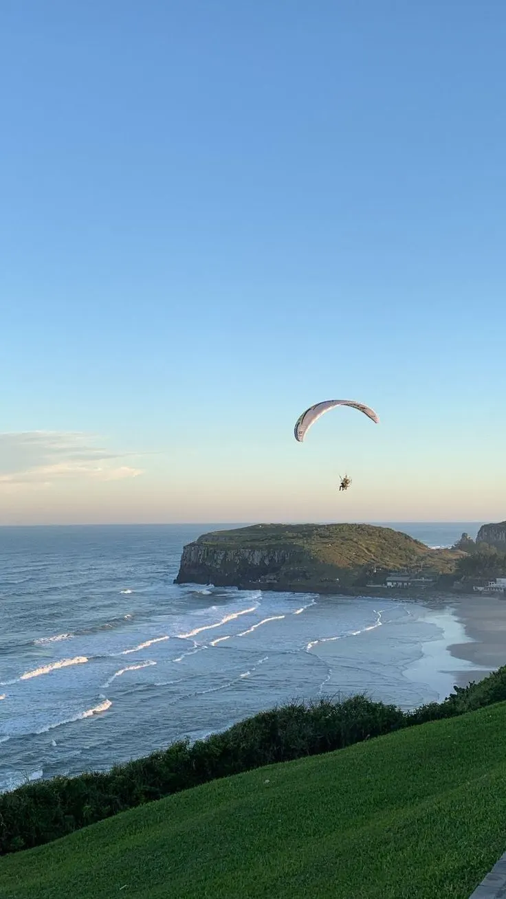 Parapente sobre a praia de Torres, com o morro ao fundo